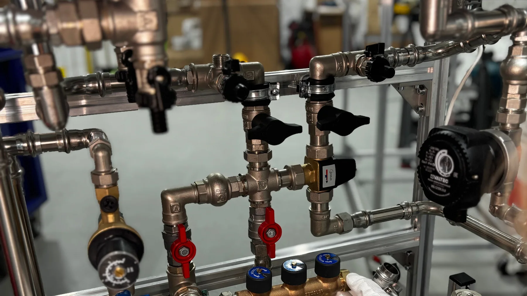 Technicien réglant des vannes sur une installation de tuyauterie industrielle